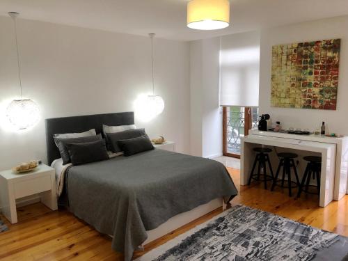 ein Schlafzimmer mit einem Bett und einem Schreibtisch sowie eine Küche in der Unterkunft Invictus Place in Porto