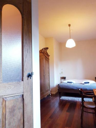 a bedroom with a bed and a room with a table at SintAnna B&B PetitHotel in Yerseke