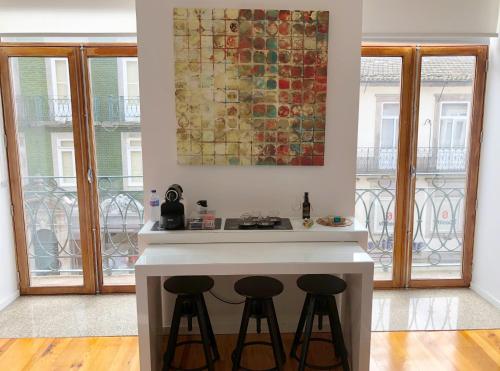 a kitchen with a counter with two stools at Invictus Place in Porto