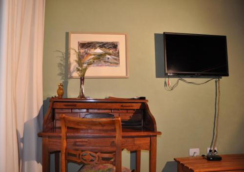 a room with a desk with a television and a chair at Hosteria Ruca Kitai in Villa Lago Rivadavia