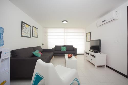 a living room with a couch and a tv at Caribbean Loft Apartment in San Andrés