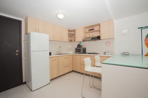 a kitchen with wooden cabinets and a white refrigerator at Caribbean Loft Apartment in San Andrés