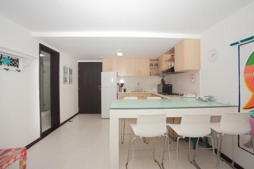 a kitchen with a blue counter and white appliances at Caribbean Loft Apartment in San Andrés