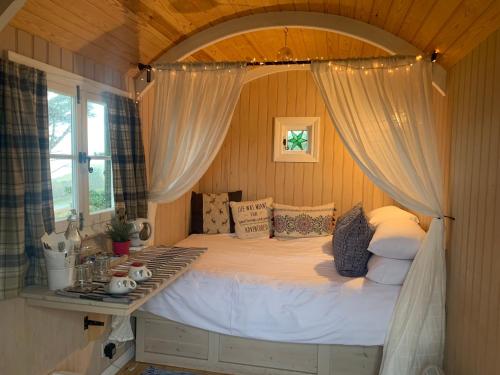 a bedroom with a large bed with a window at Loch Eyre Shepherd Hut in Portree
