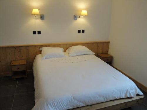 ムジェーヴにあるAppartement des Crêtetsのベッドルーム1室(白いベッド1台、枕2つ付)
