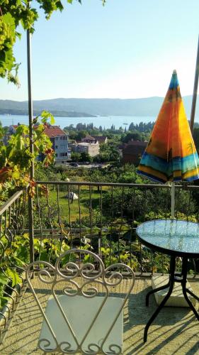 a patio with a table and an umbrella at Apartmani Bosco in Tivat
