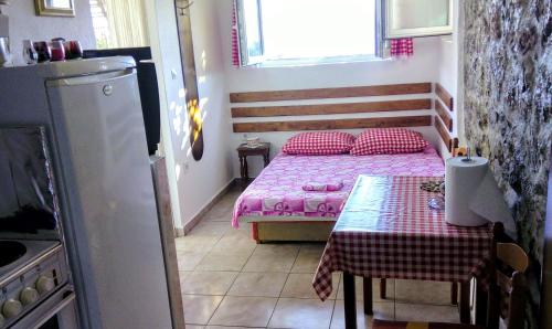a small room with a bed and a table at Apartmani Bosco in Tivat