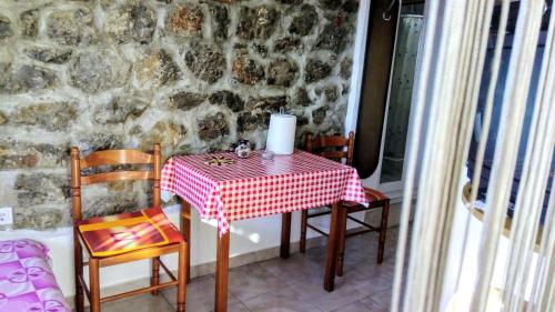 a table with a red and white checkered table cloth at Apartmani Bosco in Tivat