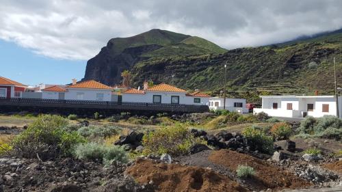 a train traveling past houses and a mountain at Casita Playa La Salemera (Mazo) in Malpaíses