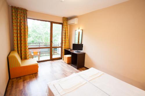a hotel room with a bed and a balcony at Bisser Hotel - Free Parking - Free Pool Access in Balchik