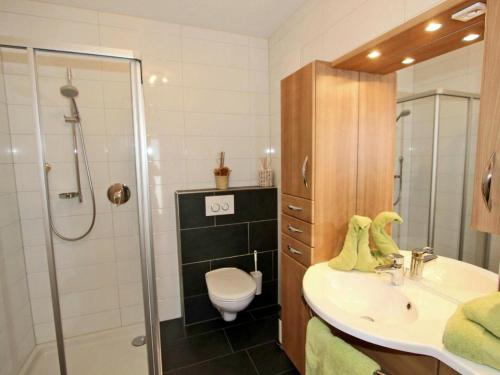 a bathroom with a sink and a shower and a toilet at Ferienwohnung Kirschner in Fügenberg