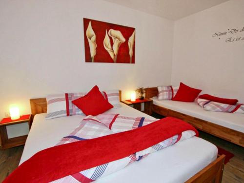 two beds in a room with red pillows at Ferienwohnung Kirschner in Fügenberg