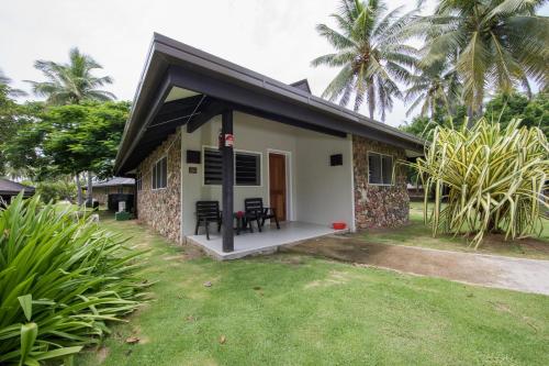 a small house with a patio and grass at Plantation Island Resort in Malolo Lailai