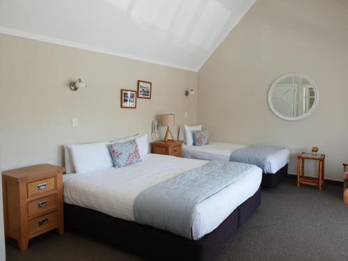 A bed or beds in a room at Hananui Lodge and Apartments