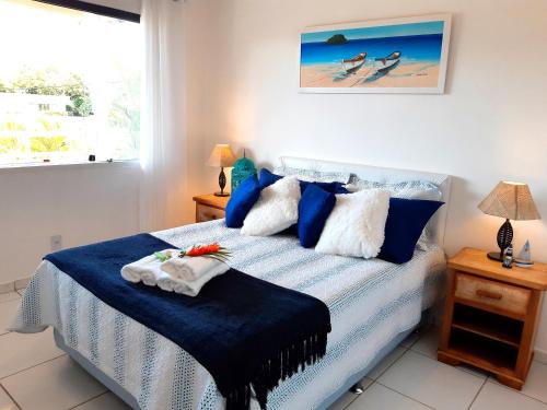 a bedroom with a bed with blue sheets and a window at Espetacular Casa 3 SUÍTES cozinha varanda vista a passos da praia in Búzios