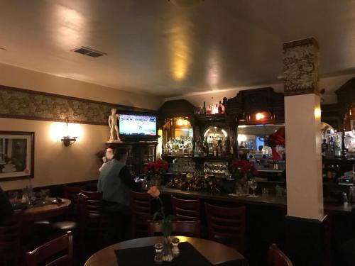 a man standing at a bar in a restaurant at Union Hotel in Benicia