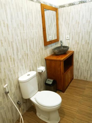 a bathroom with a toilet and a sink at D'JERO HomeStay in Ubud