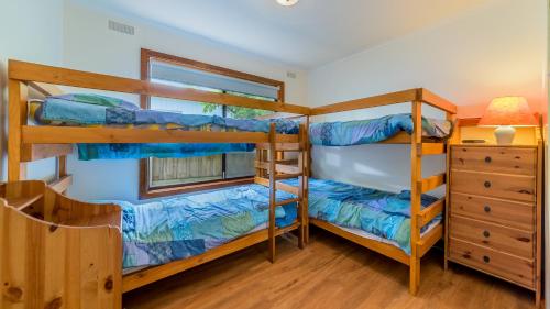 een slaapkamer met 2 stapelbedden en een dressoir bij Driftwood On Anderson Free Wifi in Inverloch
