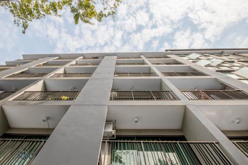 a large white building with many windows at Nidhra นิทรา in Ban Lat Krachaeng