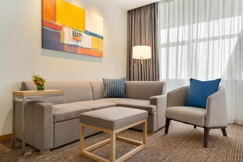 a living room with a couch and two chairs at Hyatt Place Beijing Daxing in Daxing
