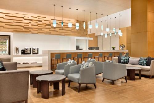 a lobby with a waiting room with chairs and tables at Hyatt Place Beijing Daxing in Daxing