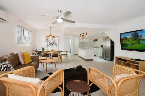 a living room with a couch and a dining room at Gosamara Apartments in Byron Bay