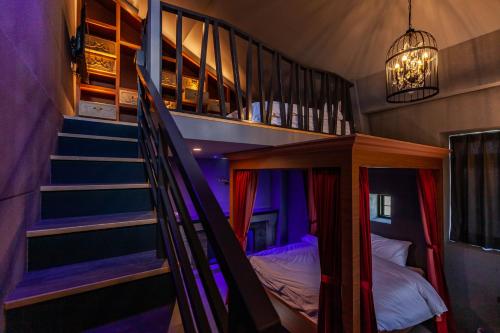 Hogwarts Castle Guest House في وجي: غرفة بسرير بطابقين ودرج