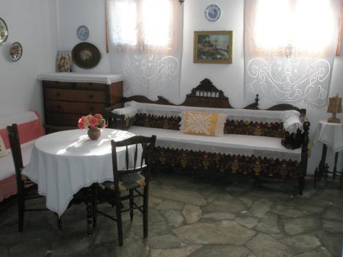 Habitación con mesa, cama, mesa y sillas. en Guesthouse Christos, en Skopelos Town