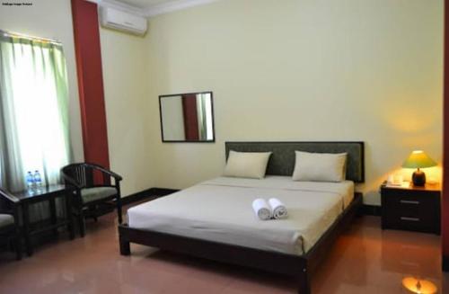 a bedroom with a bed with two towels on it at Hotel Tiger in Yogyakarta