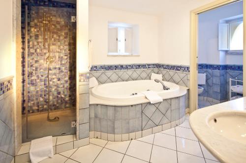 a bathroom with a tub and a shower and a sink at Grand Hotel Il Moresco in Ischia