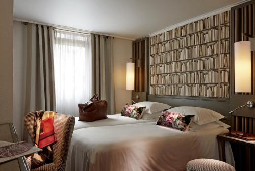 カンヌにあるホテル アメリカのベッド2台と大きな窓が備わるホテルルームです。