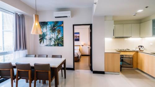 a kitchen and dining room with a table and chairs at C Suites at Mactan Newtown in Mactan
