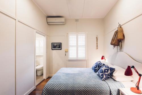 a bedroom with a bed and a bathroom at Barbara's Guesthouse in Byron Bay