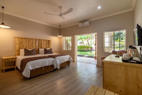 una camera con un grande letto con testiera in legno di Little Pilgrims Boutique Hotel a Hazyview