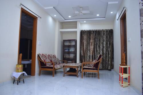 a living room with chairs and a table and a window at Govind Niwas Home Stay in Gwalior