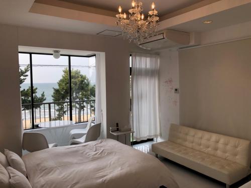 um quarto com uma cama, um sofá e uma varanda em Sea Style Resort OCEAN em Karatsu
