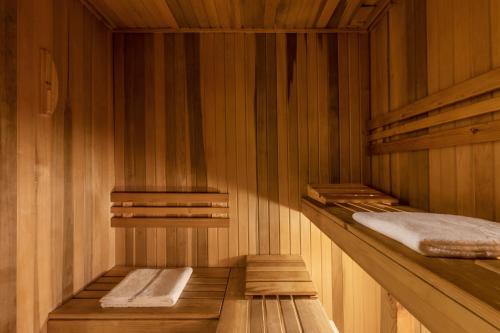 a sauna with wooden walls and wooden shelves and towels at Herbert Samuel Jerusalem in Jerusalem