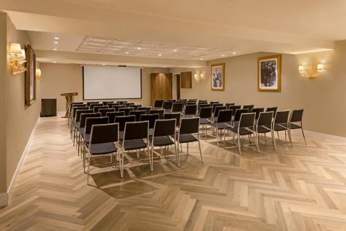 a conference room with chairs and a projection screen at Herbert Samuel Jerusalem in Jerusalem