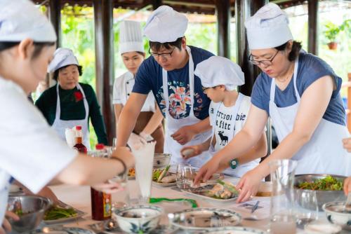 a group of people preparing food in a kitchen at RiverTown Hoi An Resort & Spa in Hoi An