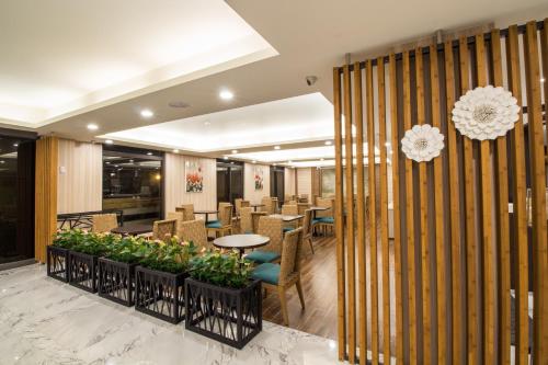 a restaurant with tables and chairs and plants at Dong Tair Spa Hotel in Wenquan