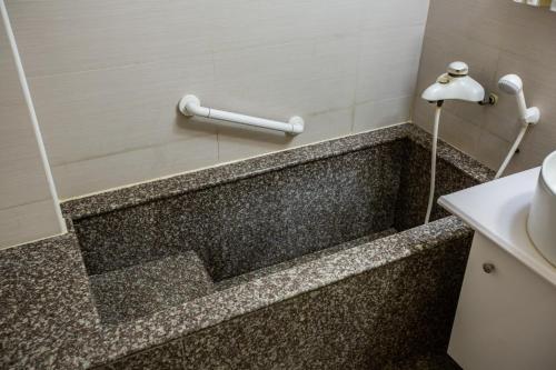 y baño con bañera y lavamanos. en Dong Tair Spa Hotel en Wenquan