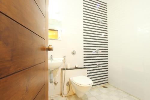 a bathroom with a toilet and a sink at The Grand Inn Mysore in Mysore