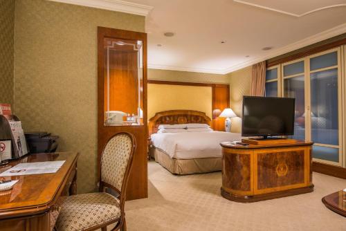 a hotel room with a bed and a flat screen tv at Evergreen Laurel Hotel Taipei in Taipei
