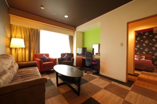 a living room with a couch and a table at Quintessa Hotel Iseshima in Shima