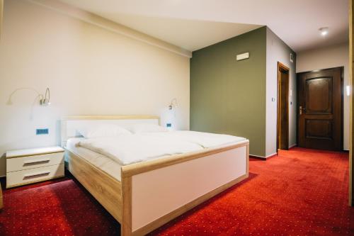 a bedroom with a large bed and a red carpet at Boutique Hotel Barrel in Sesvete