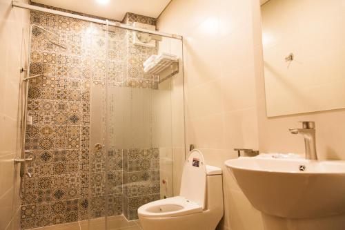 a bathroom with a shower and a toilet and a sink at SPRING HOTEL in Thu Dau Mot