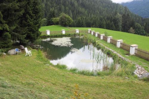 a bridge over a small pond in a field at Schloss Berg Klösterle in Zedlitzdorf
