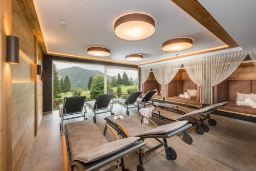 a salon with chairs and a waiting room with mountains at Apart & Suiten Hotel WEIDEN in Schladming
