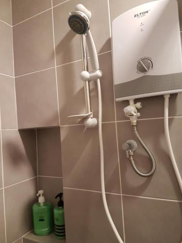 a shower with a blow dryer in a bathroom at Southville Stay 2 @ Savanna Executive Suite in Kampong Tangkas