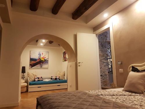 1 dormitorio con cama y puerta abovedada en Suite Home 5 Terre, en La Spezia